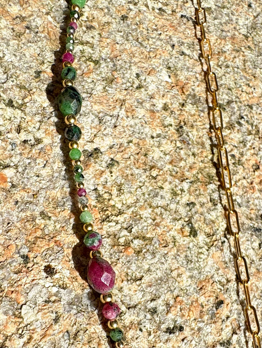 Vert, rose, or - des couleurs qui claquent et vibrent. Une pièce pleine d’énergie et de style.
Collier sur chaîne maille rectangle en or laminé - Pendentif "goutte" de 6 cm en rubis zoïsite et breloque rayon de soleil en or laminé - Perles de rubis zoïsite et en or laminé 14 carats.