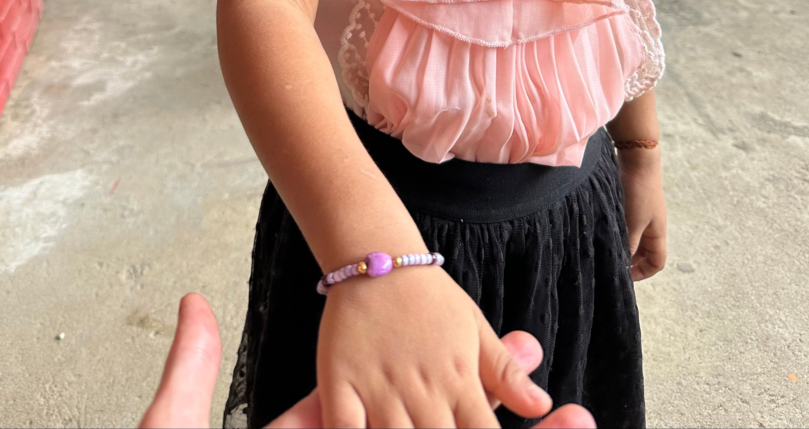 petite fille cambodgienne portant un bracelet sur elastique capsule humani